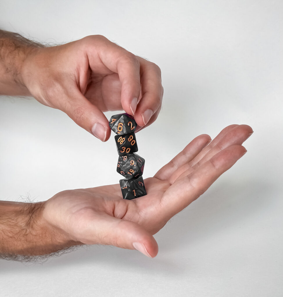 hands holding and balancing polyhedral dice set for tabletop gaming hands holding and balancing polyhedral dice set for tabletop gaming